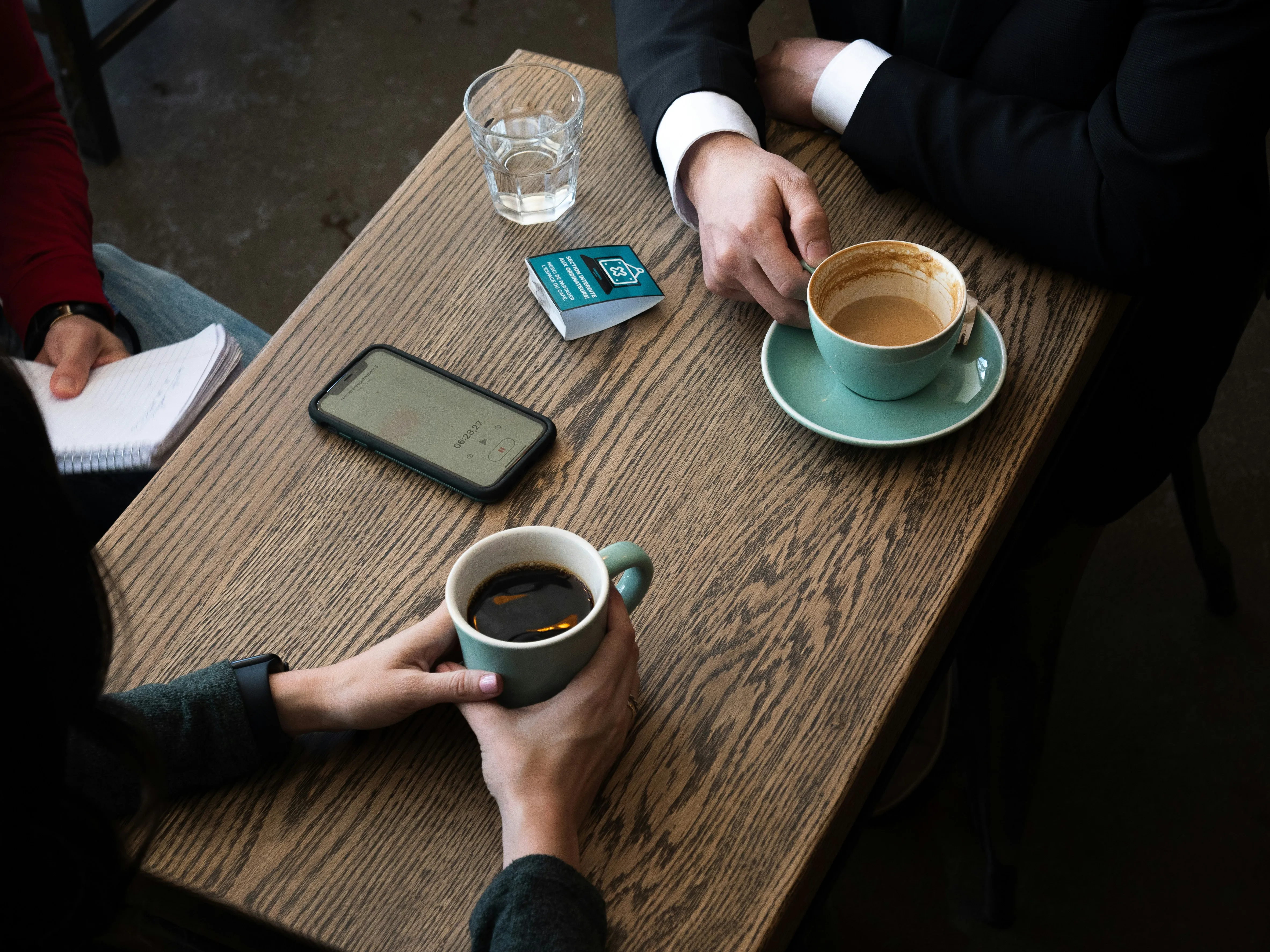 Two people talking over coffee at a table