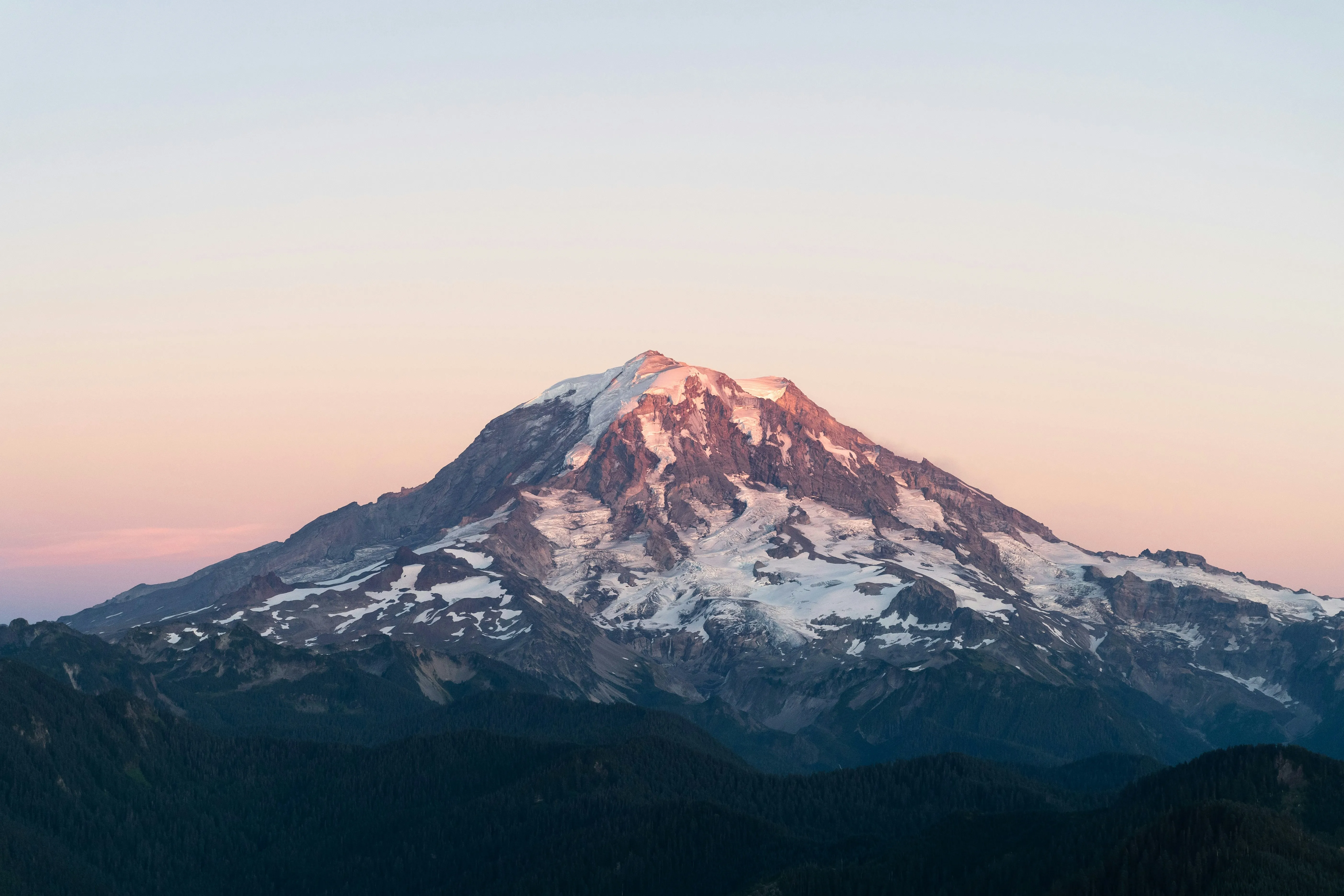 A snow-capped Rocky Mountain peak lit by alpenglow at sunset